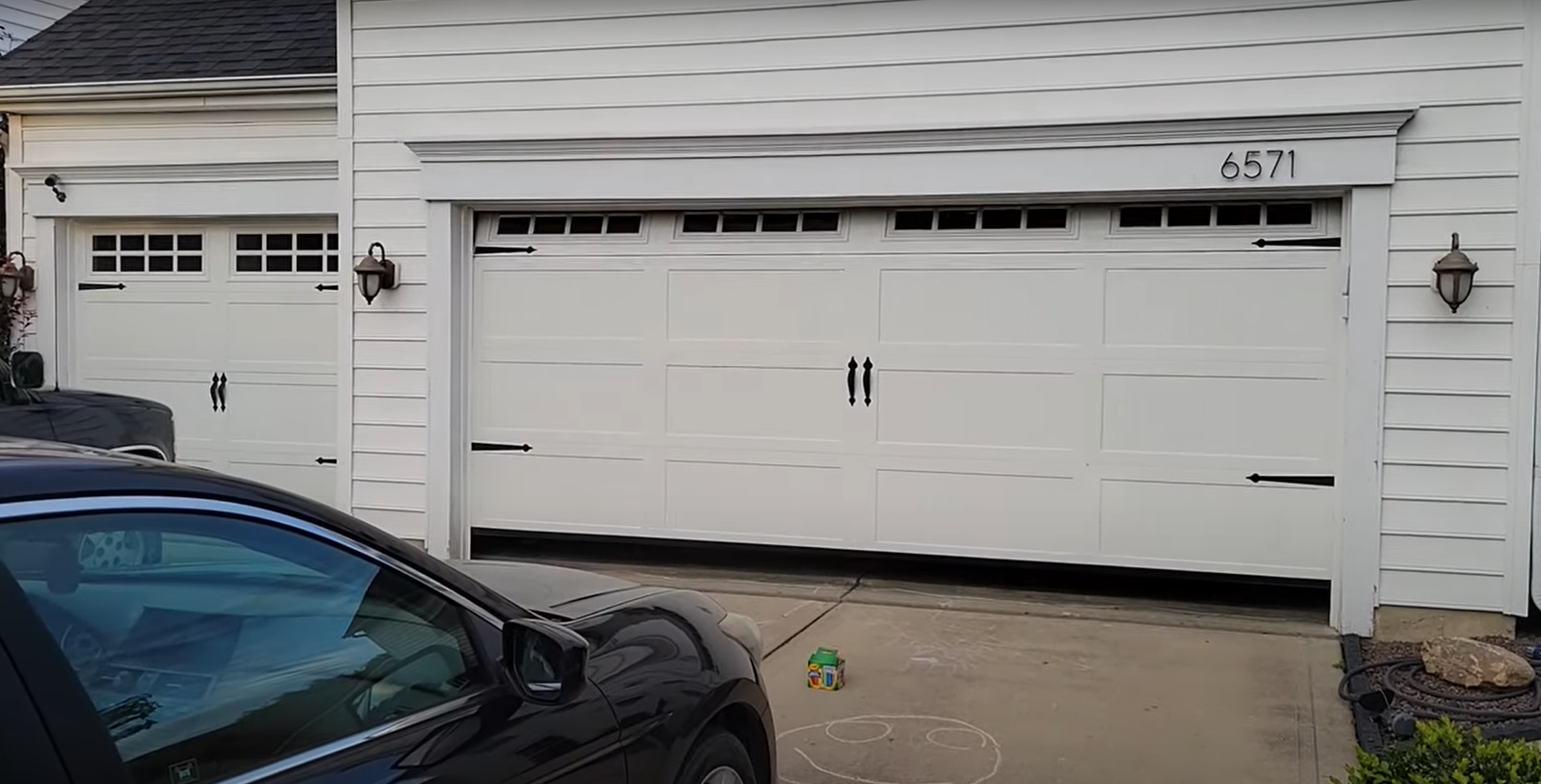 A local garage door repair technician from Granville, Ohio, inspects and services a residential garage door, demonstrating expert maintenance and installation as part of local garage door repair services.